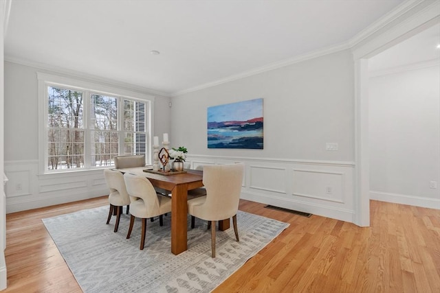 dining area featuring crown molding and light hardwood / wood-style floors