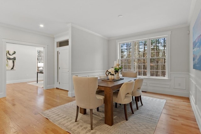 dining room with ornamental molding and light wood-type flooring