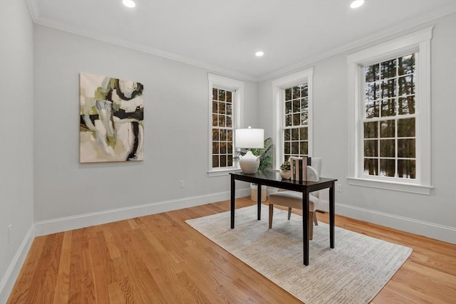 home office featuring crown molding, a wealth of natural light, and light wood-type flooring