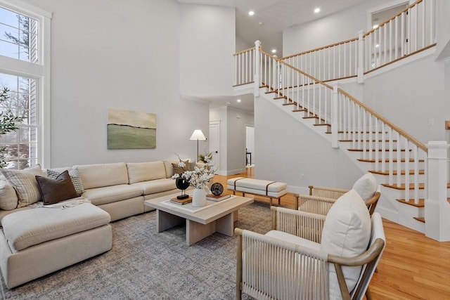 living room with a towering ceiling and hardwood / wood-style floors