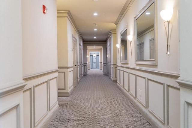 hallway featuring crown molding, recessed lighting, light colored carpet, and a decorative wall