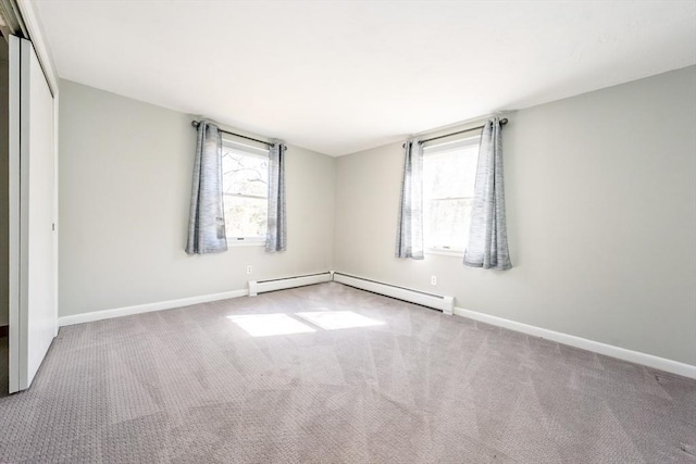 carpeted spare room featuring baseboards, a baseboard radiator, and a healthy amount of sunlight