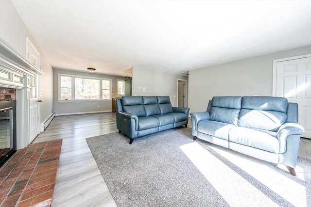 living room with a baseboard heating unit, wood finished floors, and baseboards