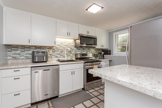 168 Varao Ave, Somerset, MA 02726 - kitchen featuring stainless steel appliances, light floors, white cabinets, and decorative backsplash