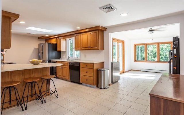 168 Varao Ave, Somerset, MA 02726 - kitchen featuring black dishwasher, a kitchen breakfast bar, light tile patterned flooring, a baseboard heating unit, and freestanding refrigerator
