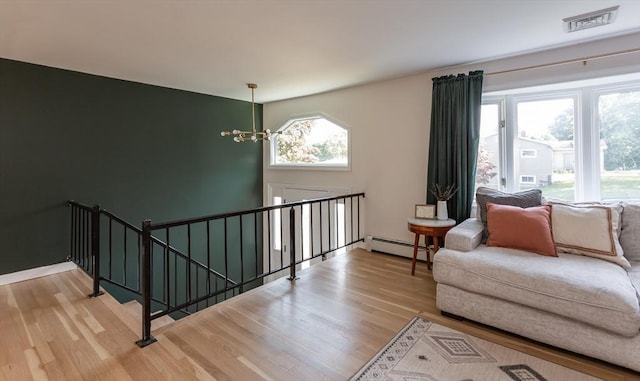 168 Varao Ave, Somerset, MA 02726 - living area with a baseboard radiator, wood finished floors, and a chandelier
