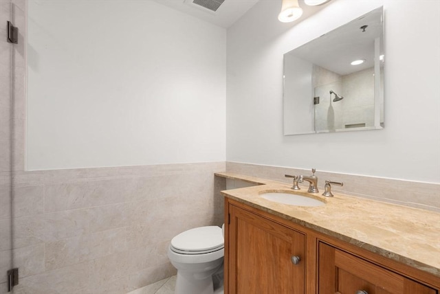 416 Marlborough Unit 608, Boston, MA 02116 - bathroom featuring vanity, a shower with shower door, wainscoting, tile walls, and tile patterned flooring