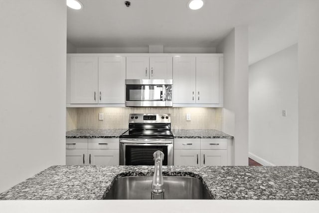 416 Marlborough Unit 608, Boston, MA 02116 - kitchen featuring appliances with stainless steel finishes, dark stone counters, white cabinetry, and recessed lighting