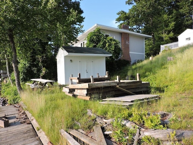 rear view of house featuring a storage unit