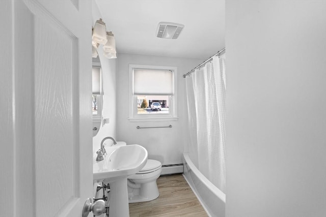 full bathroom with visible vents, toilet, wood finished floors, shower / tub combo with curtain, and baseboard heating