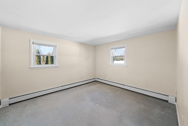 empty room featuring a baseboard heating unit and concrete floors