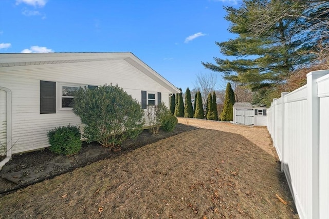 view of home's exterior featuring a storage shed, fence, and an outbuilding