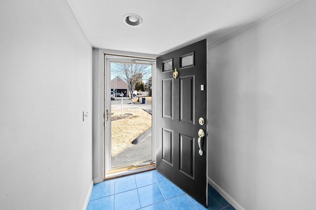 doorway with tile patterned flooring and baseboards