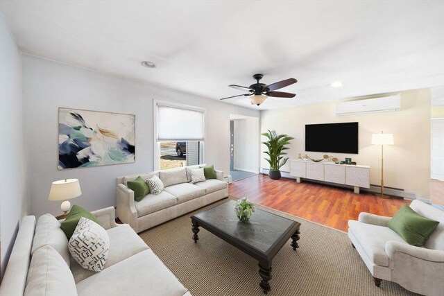 living area with ceiling fan, a wall mounted air conditioner, wood finished floors, and a baseboard radiator