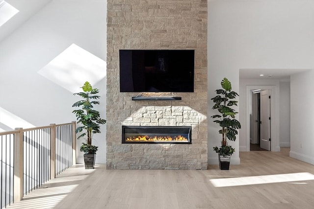 room details featuring a fireplace, baseboards, and wood finished floors