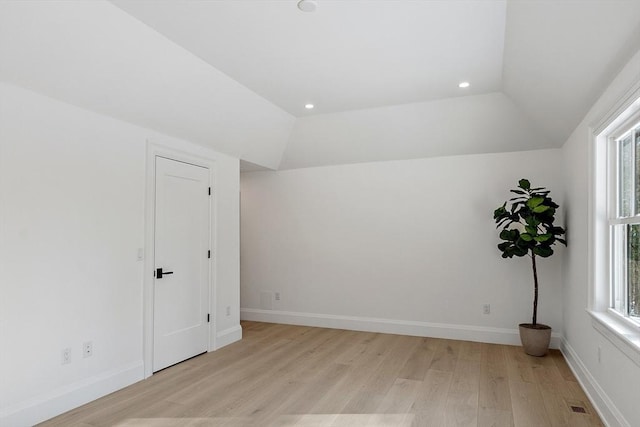 interior space featuring lofted ceiling, light wood finished floors, baseboards, and recessed lighting