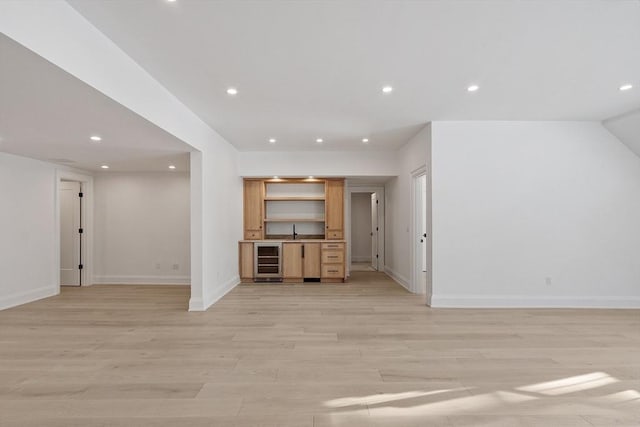 unfurnished living room with wine cooler, light wood-style flooring, baseboards, and recessed lighting