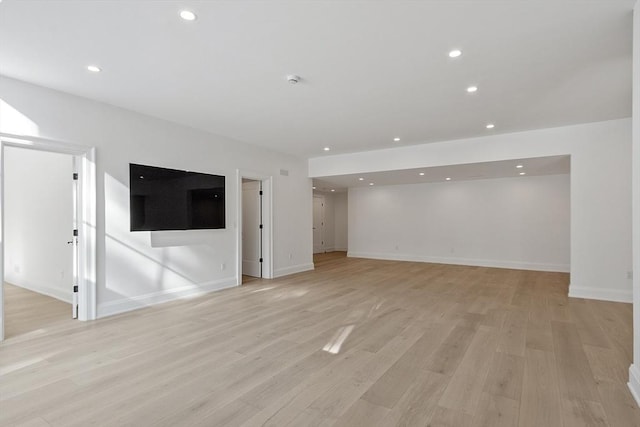 unfurnished living room with light wood-style flooring, baseboards, and recessed lighting