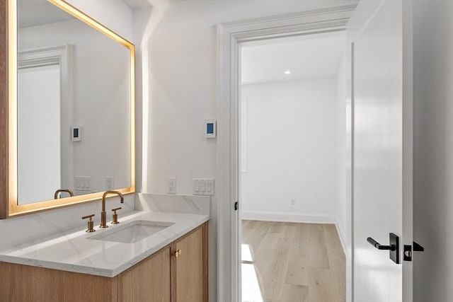 bathroom featuring vanity, baseboards, and wood finished floors