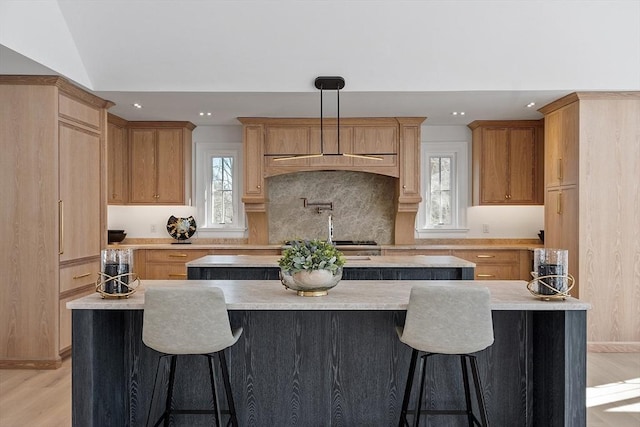 kitchen with a center island, decorative light fixtures, and plenty of natural light