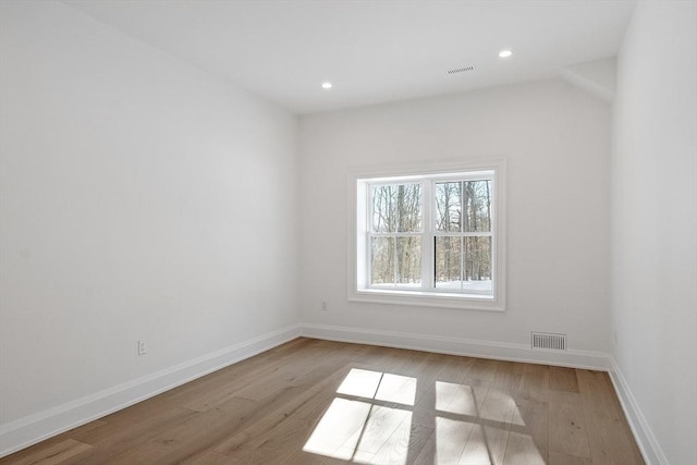 spare room featuring baseboards, visible vents, and light wood-style floors