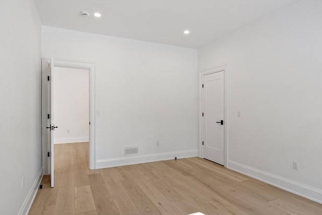 unfurnished room featuring light wood-type flooring, visible vents, baseboards, and recessed lighting