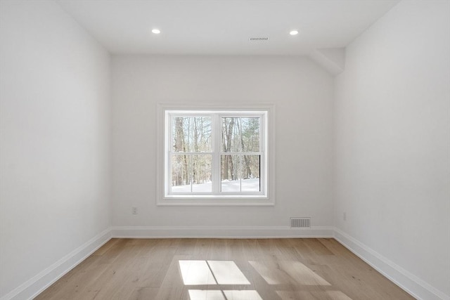 unfurnished room with recessed lighting, light wood-type flooring, visible vents, and baseboards