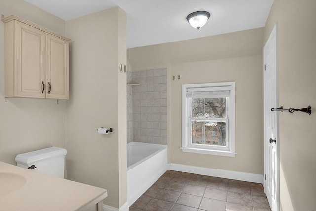 full bathroom with tile patterned floors, vanity, tiled shower / bath, and toilet