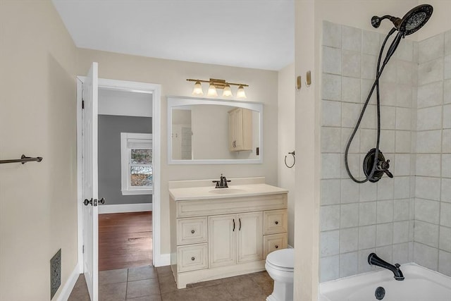 full bathroom with tiled shower / bath combo, toilet, wood-type flooring, and vanity