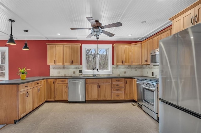 kitchen with sink, hanging light fixtures, ceiling fan, appliances with stainless steel finishes, and kitchen peninsula