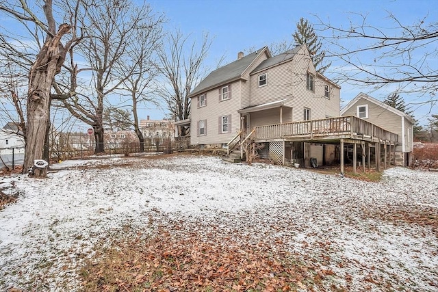 snow covered house with a deck