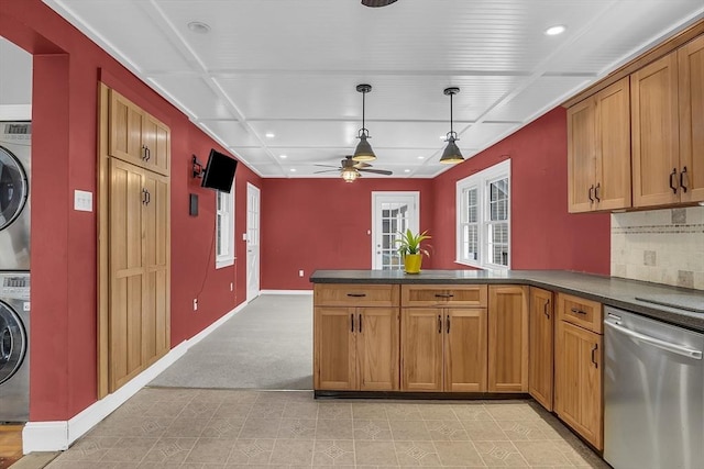 kitchen featuring dishwasher, ceiling fan, decorative light fixtures, kitchen peninsula, and stacked washer / dryer