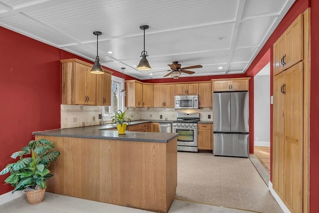 kitchen with kitchen peninsula, pendant lighting, stainless steel appliances, and decorative backsplash