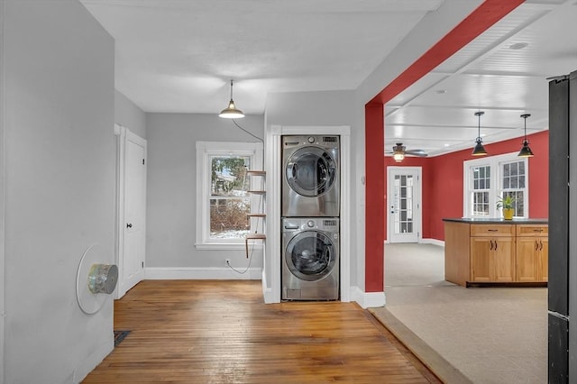 washroom with ceiling fan, stacked washer and dryer, french doors, and light wood-type flooring