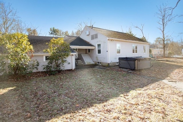 rear view of house with a hot tub