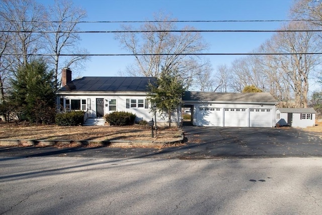 ranch-style home with solar panels and a garage