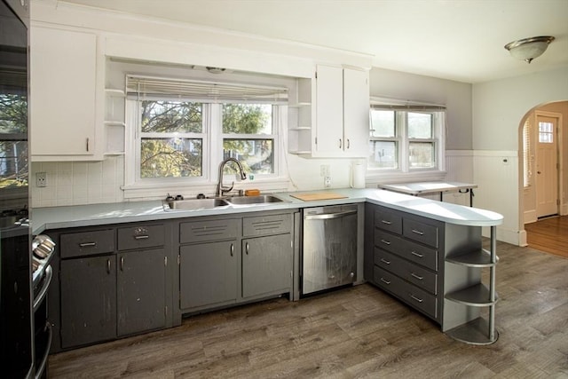 kitchen with white cabinets, dark hardwood / wood-style flooring, stainless steel dishwasher, and sink