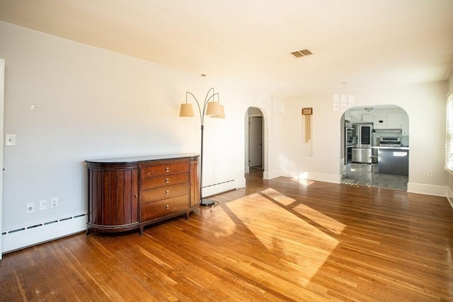 interior space with hardwood / wood-style flooring and baseboard heating