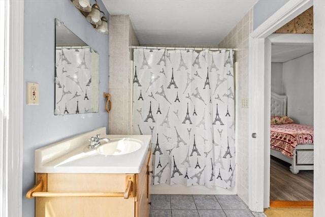 bathroom featuring a shower with shower curtain, ensuite bath, tile patterned flooring, and vanity