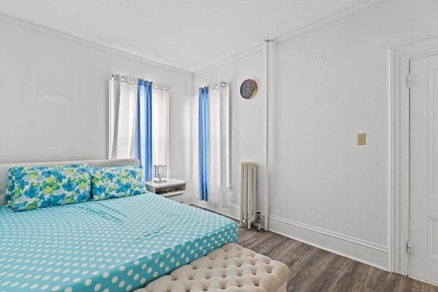 bedroom featuring radiator, baseboards, ornamental molding, and wood finished floors