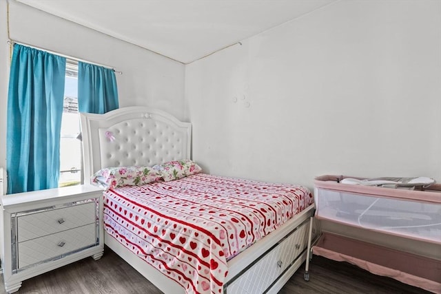 bedroom with multiple windows and wood finished floors