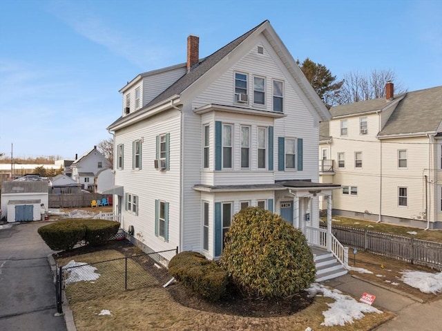 view of front of home with cooling unit, fence, and a chimney