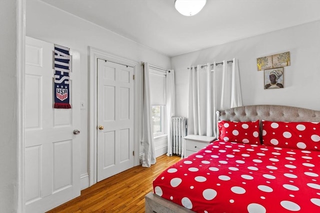 bedroom featuring radiator and wood finished floors