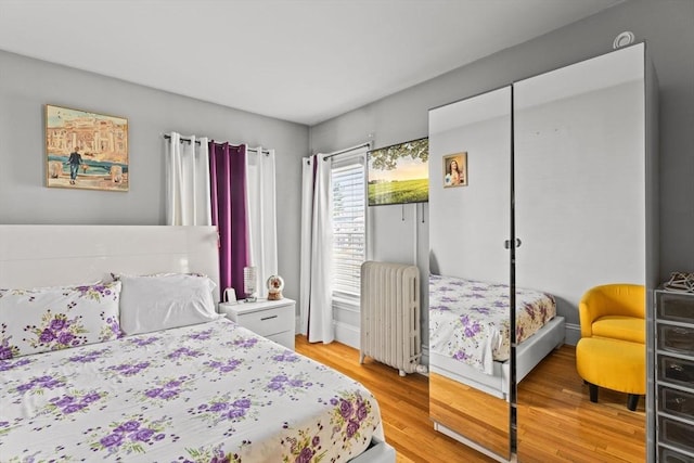 bedroom with light wood-style flooring and radiator heating unit