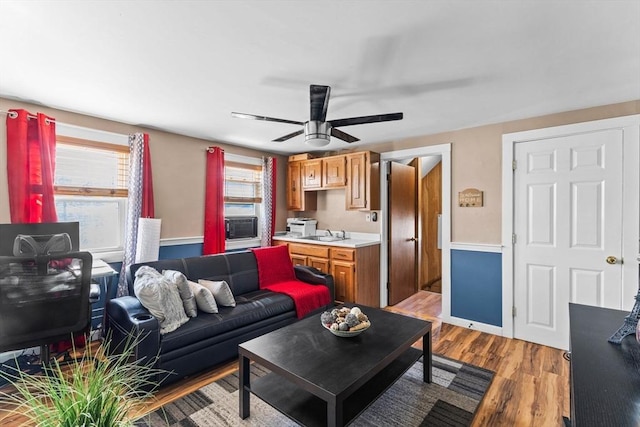 living room featuring ceiling fan, wood finished floors, and a wealth of natural light