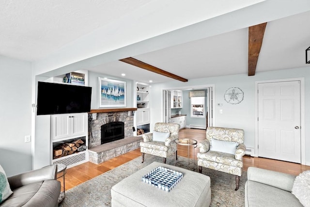 living room with beamed ceiling, wood finished floors, and a fireplace