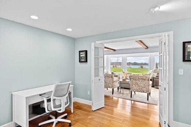 office area with recessed lighting, baseboards, light wood-style floors, and a water view