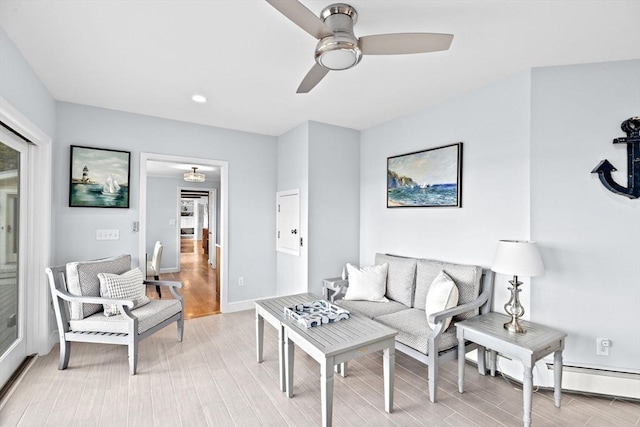 living room with light wood-style flooring, baseboards, and ceiling fan