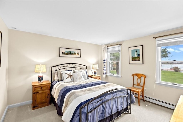 bedroom featuring baseboard heating, light carpet, multiple windows, and baseboards