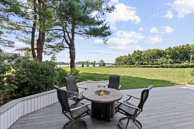 wooden deck with a lawn and a fire pit